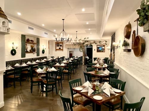 The long dining room with tables set for dinner under a chandelier