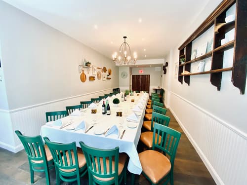 A long table set for a large party in a narrow private dining room