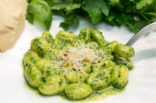 Gnocchi in pesto sauce with grated cheese