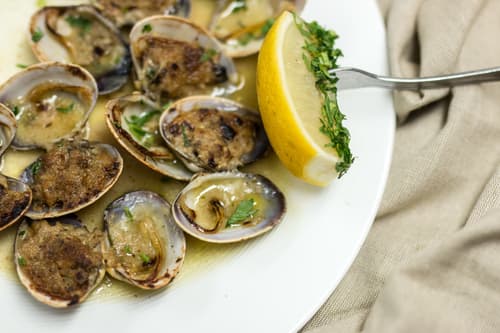 Baked stuffed clams with a lemon wedge
