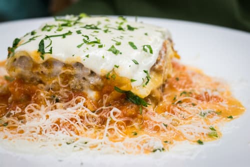 Baked lasagna with tomato sauce, melted cheese and parsley