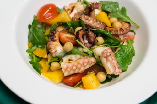 Octopus salad with arugula, cherry tomatoes, yellow peppers and chickpeas