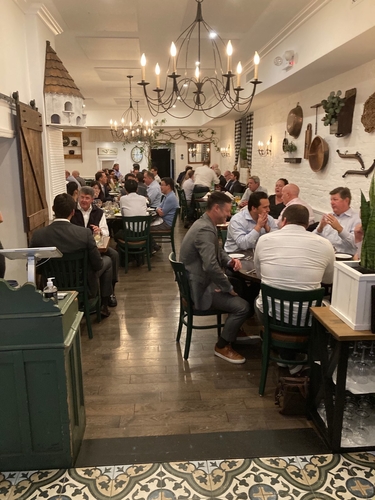 Guests dining in the long main dining room under a chandelier